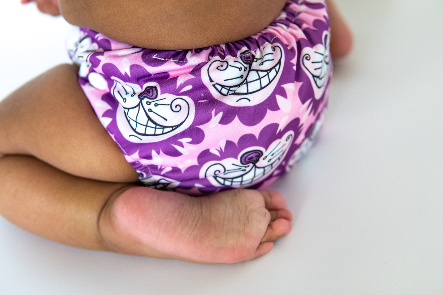 A toddler wearing a cheshire cat themed cloth nappy