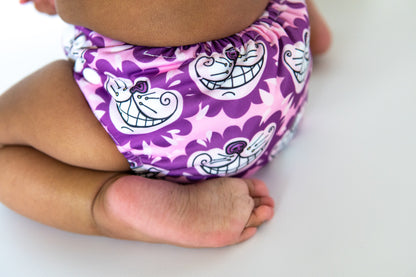 A toddler wearing a cheshire cat themed cloth nappy